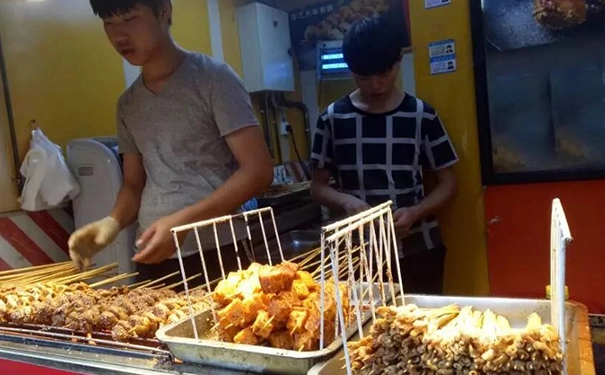 有这么两个年轻小伙合开小吃摊，走在大街上都是咬着烤串的人！